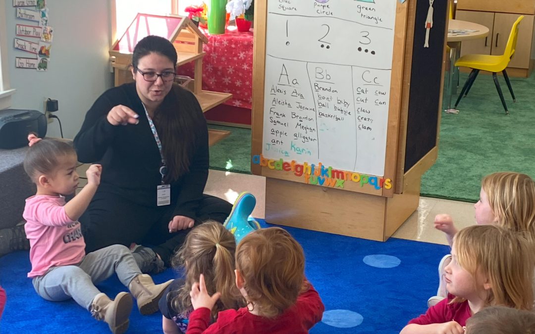 Head Start teacher using American Sign Language with young students.