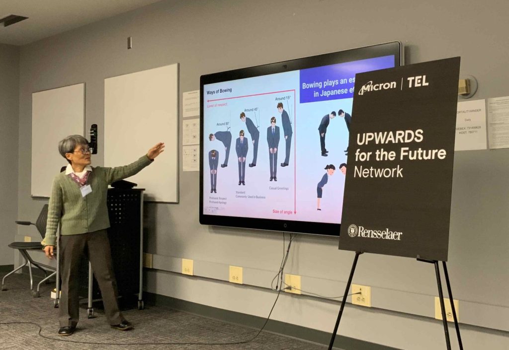 Woman pointing at smart board that explains proper bowing in Japanese culture.