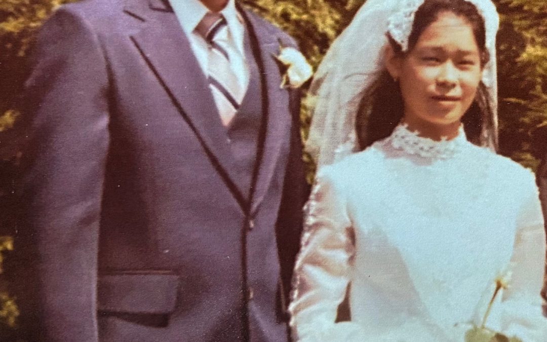 Couple getting married. Husband in suit. Bride in veil and white dress.