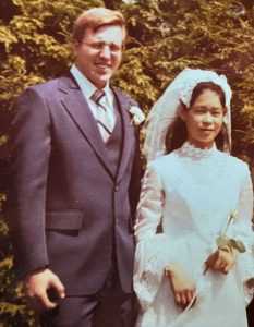 Couple getting married. Husband in suit. Bride in veil and white dress.