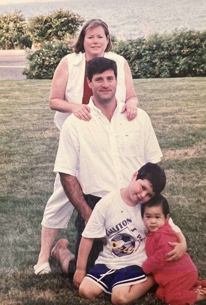 Family of four with water behind them.